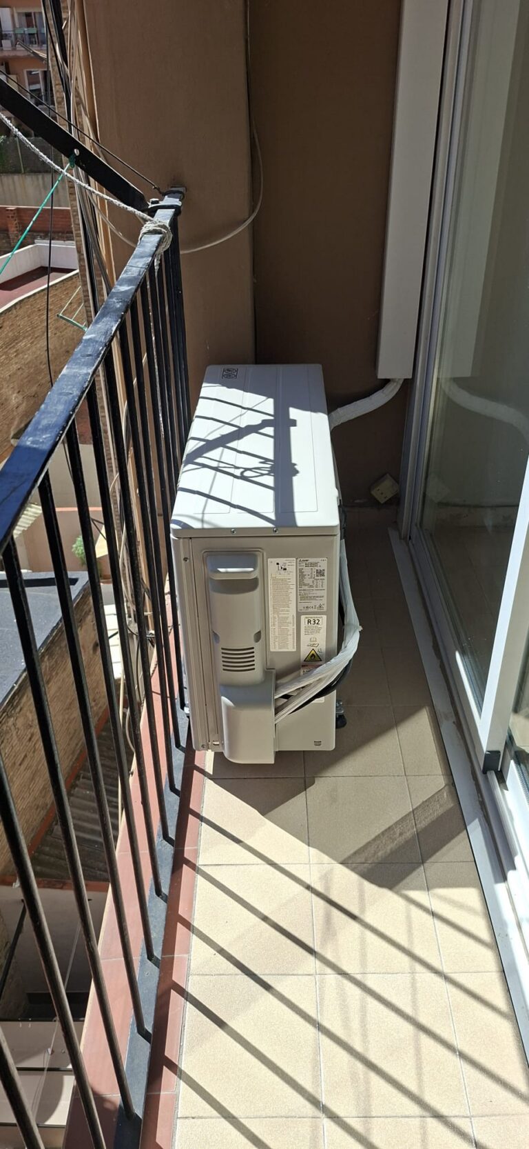 Mitsubishi Electric air conditioning outdoor unit in an enclosed balcony, installed by JAG Alcaide