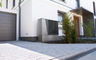Unidad exterior de bomba de calor junto a una vivienda