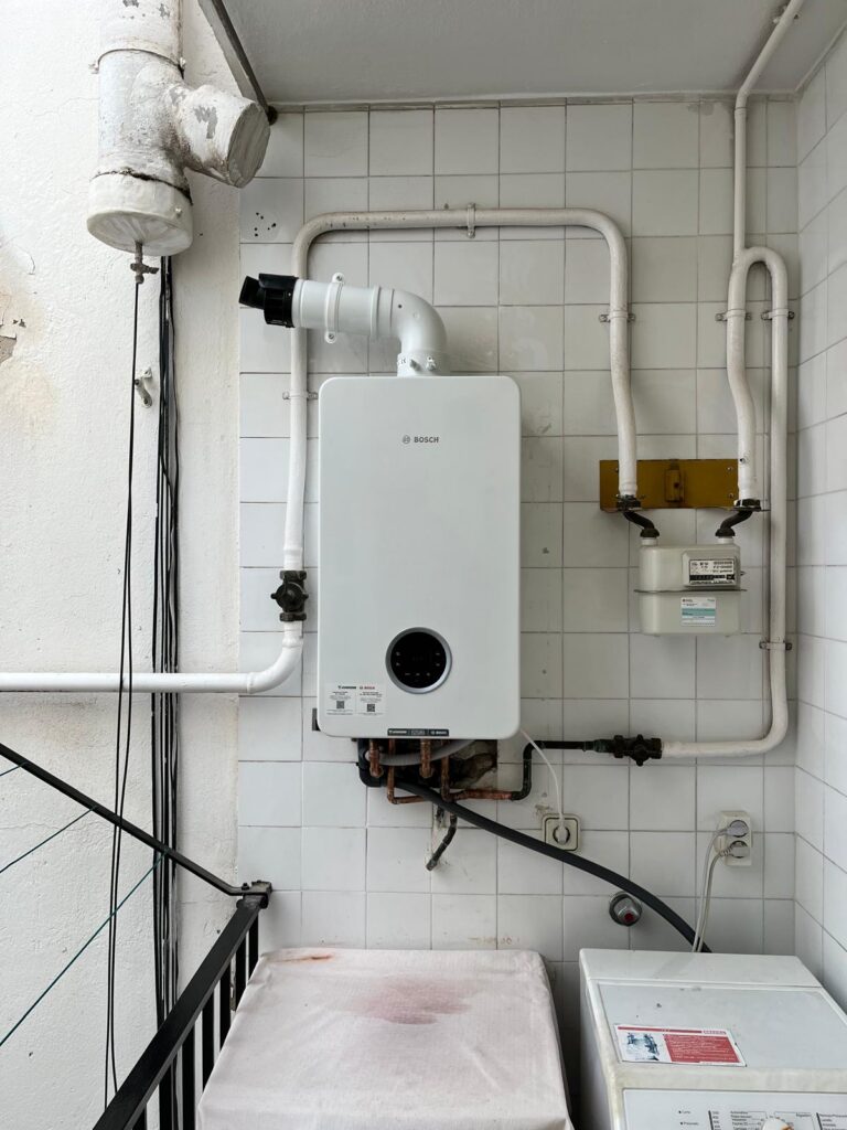 Caldera de condensación Junkers Bosch instalada por JAG Alcaide en una galería, junto al contador de gas