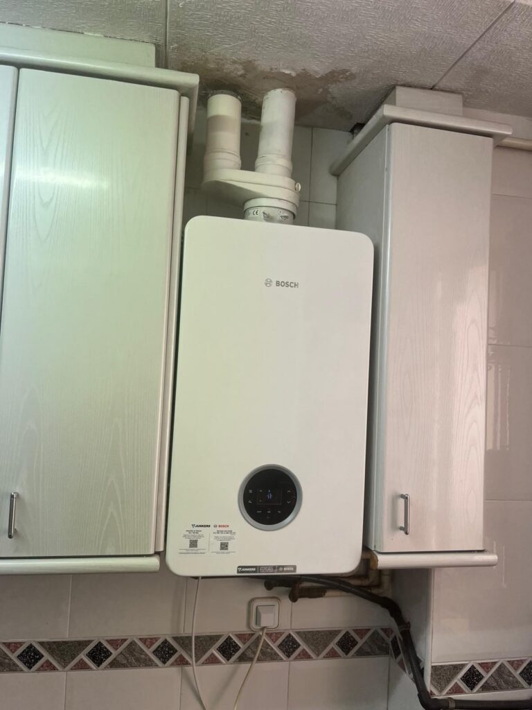 Caldera de condensación Junkers Bosch instalada por JAG Alcaide entre los armarios de la cocina